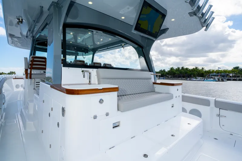 Slide: The Image of Luxurious 2027 HCB 65 Estrella yacht interior with seating and sink, docked by scenic waterfront. - 41