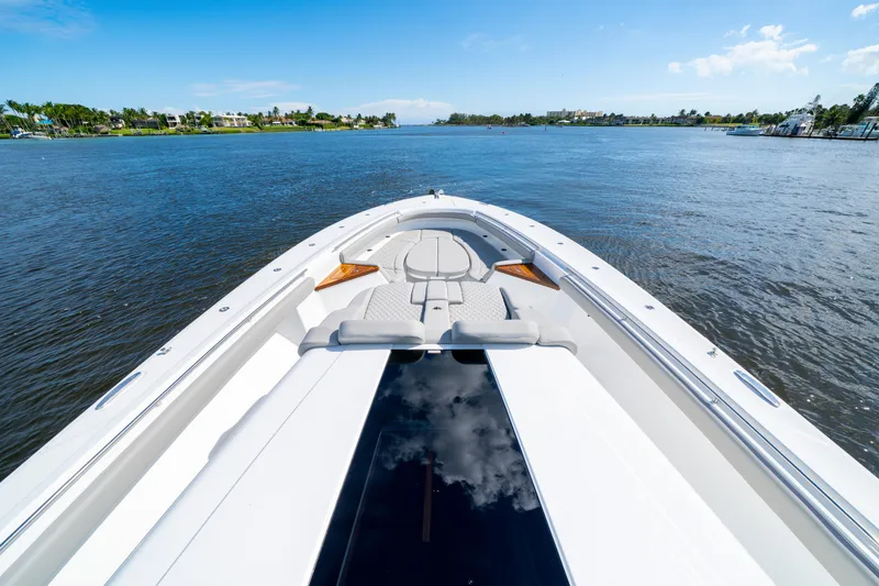 Slide: The Image of Luxurious 2027 HCB 65 Estrella yacht cruising on a serene waterway under a clear blue sky. - 59
