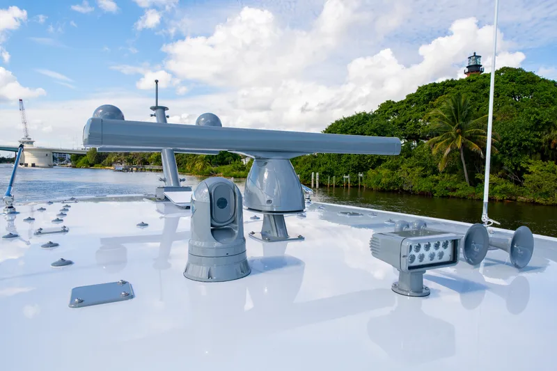 Slide: The Image of 2027 HCB 65 Estrella yacht deck with advanced navigation equipment, near lush greenery and lighthouse. - 61