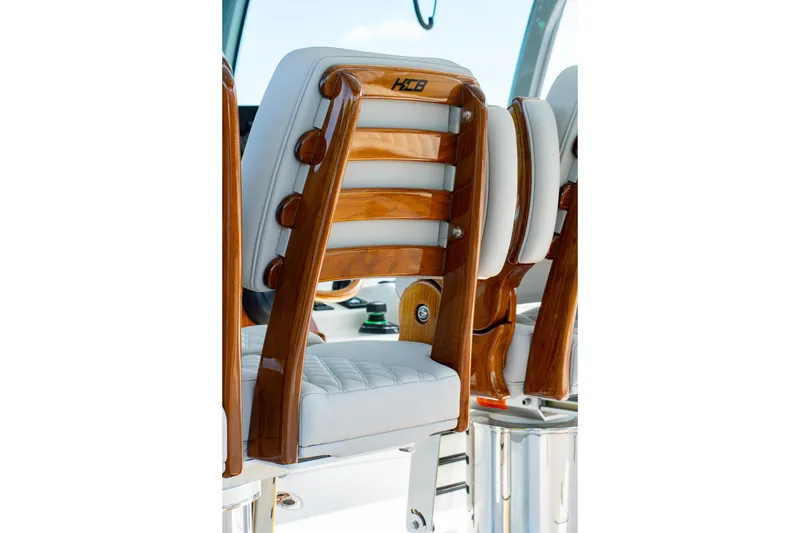 Slide: The Image of Luxurious seating on 2027 HCB 65 Estrella boat with polished wood and white upholstery. - 78