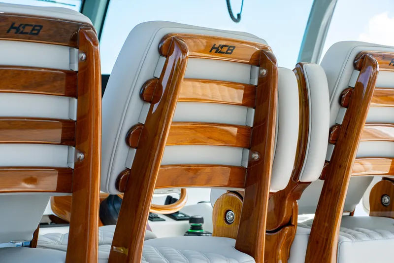 Slide: The Image of Luxury seating on 2027 HCB 65 Estrella boat, featuring elegant wood and white upholstery. - 79