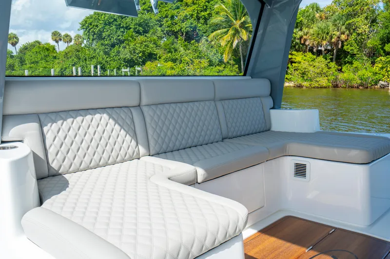 Slide: The Image of Luxurious seating on the 2027 HCB 65 Estrella yacht, featuring quilted upholstery and scenic water views. - 82