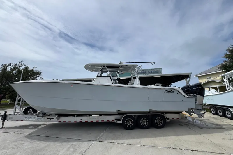 The Image of 2020 Invincible 35 Catamaran on trailer, parked outdoors under cloudy sky. - 1