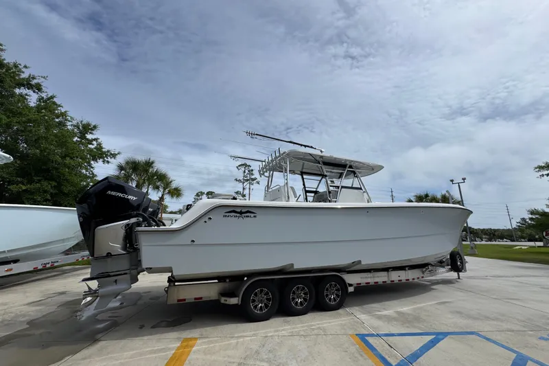 Slide: The Image of 2020 Invincible 35 Catamaran on trailer, featuring Mercury engines, parked outdoors. - 12