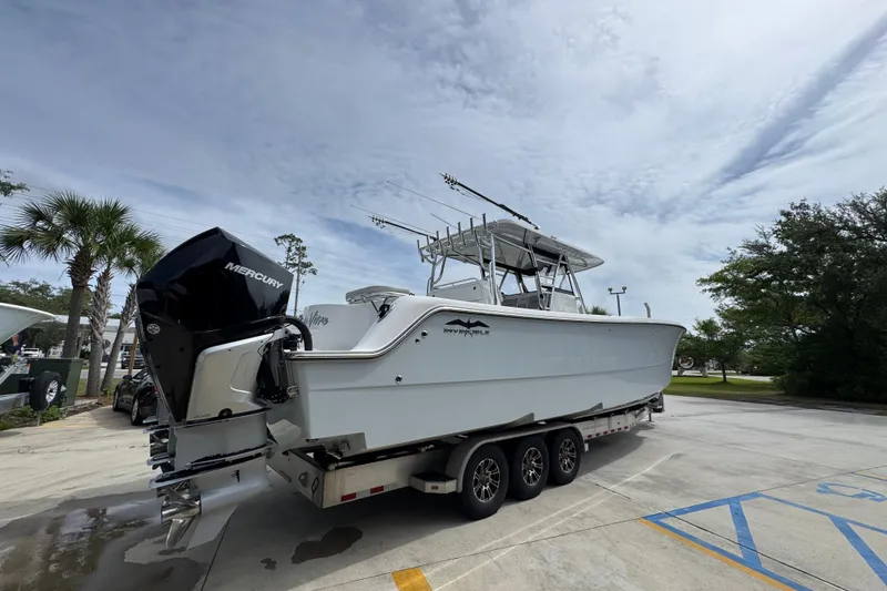Slide: The Image of 2020 Invincible 35 Catamaran on trailer with Mercury outboard engines, parked outdoors. - 13