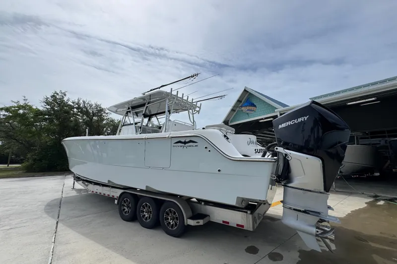 Slide: The Image of 2020 Invincible 35 Catamaran on trailer, featuring dual Mercury engines, parked outdoors. - 17