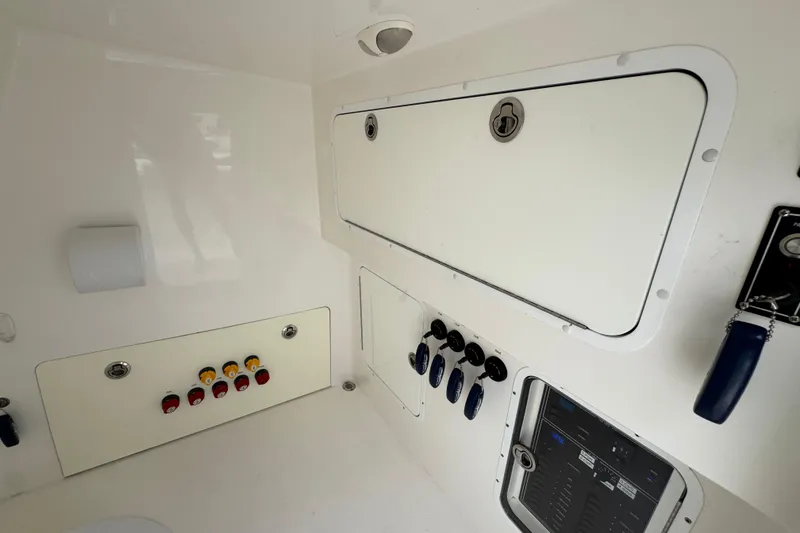 Slide: The Image of Interior view of a 2020 Invincible 35 Catamaran control panel with switches and storage compartments. - 37