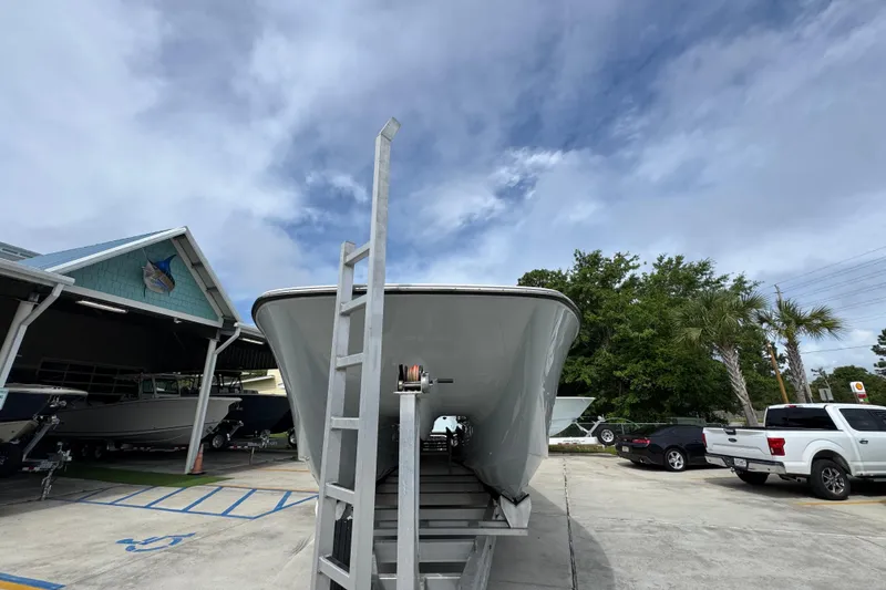 Slide: The Image of 2020 Invincible 35 Catamaran on trailer, parked outdoors under cloudy sky. - 6