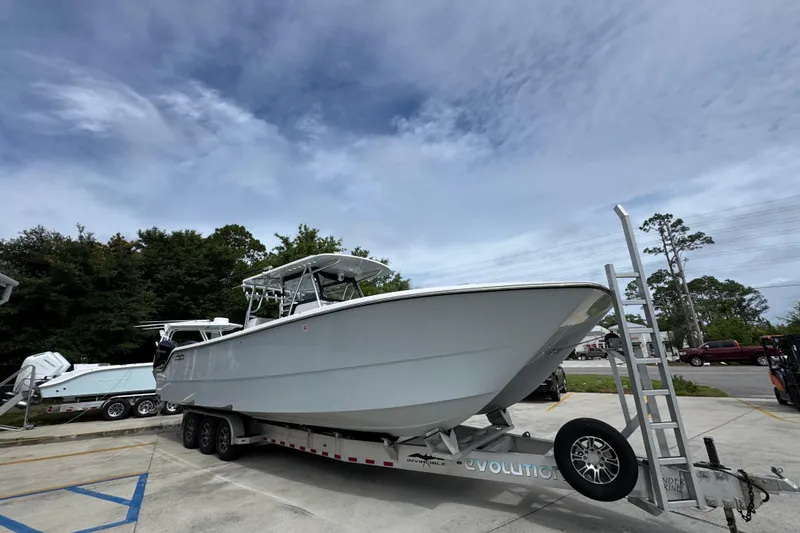 Slide: The Image of 2020 Invincible 35 Catamaran on trailer, parked outdoors under a cloudy sky. - 8
