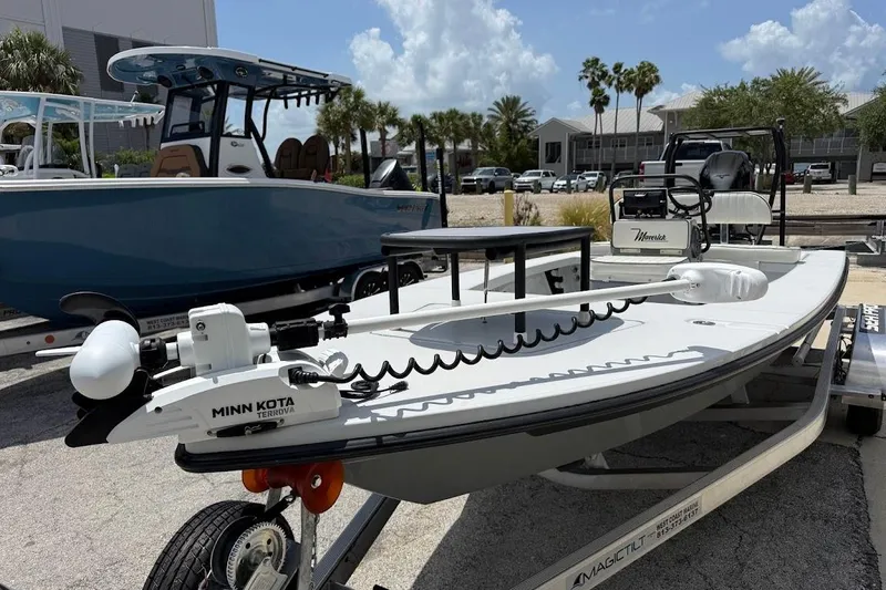 Slide: The Image of 2023 Maverick 18 HPX-V boat with Minn Kota Terrova motor on trailer, parked outdoors. - 2