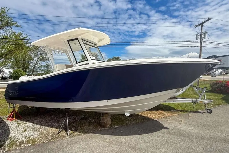 The Image of 2025 Robalo R270 Center Console boat displayed outdoors under a blue sky. - 0