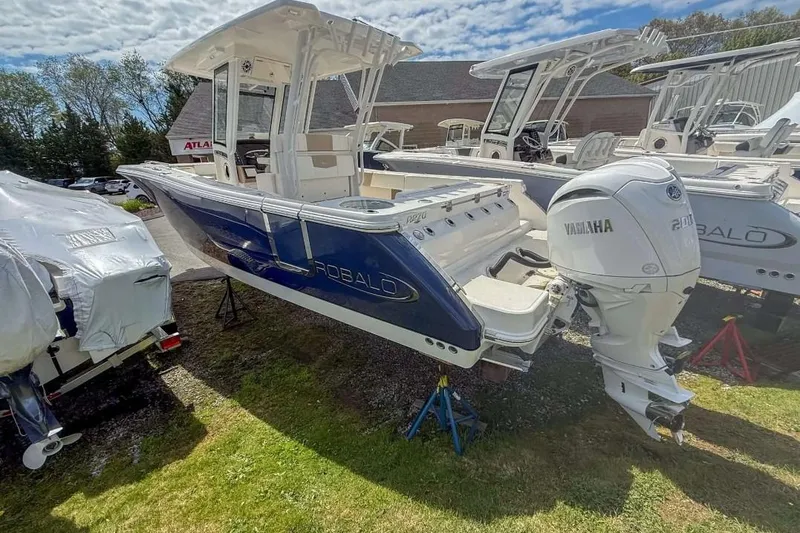 Slide: The Image of 2025 Robalo R270 Center Console boat with Yamaha engine on display outdoors. - 14