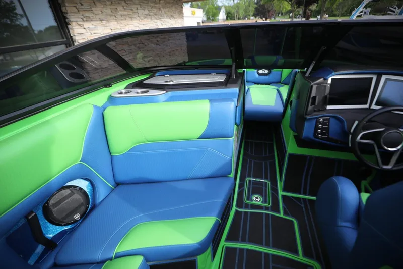 Slide: The Image of 2022 Centurion Ri265 boat interior with vibrant blue and green seating and modern dashboard. - 10