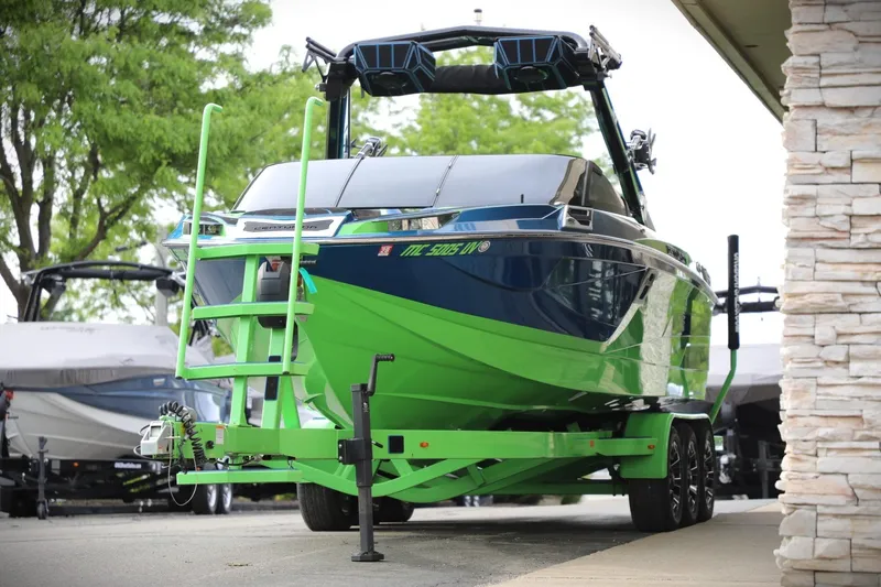 Slide: The Image of 2022 Centurion Ri265 boat in vibrant green and blue on a trailer. - 13