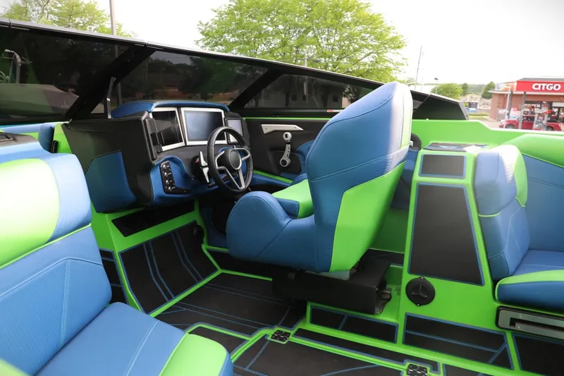 Slide: The Image of Interior of 2022 Centurion Ri265 boat with vibrant blue and green seating and modern dashboard. - 3