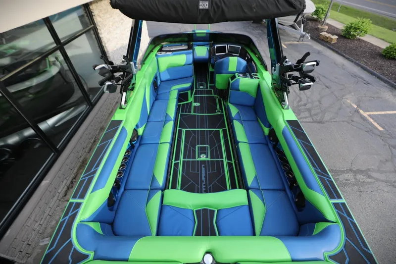 Slide: The Image of 2022 Centurion Ri265 boat interior with vibrant blue and green seating, showcasing modern design. - 4