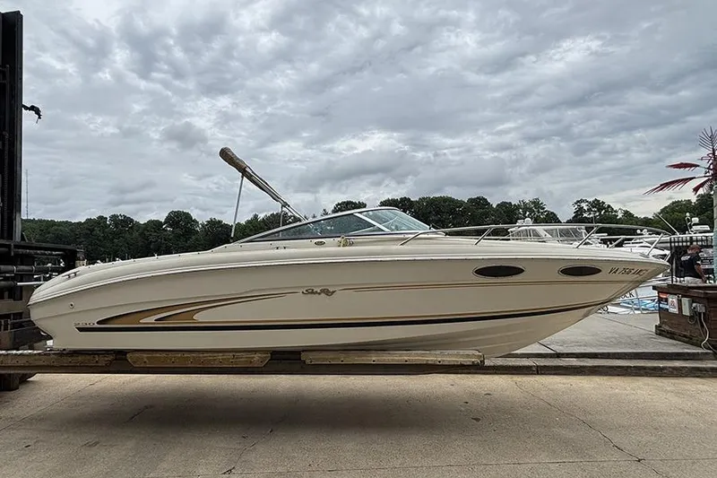 The Image of 2000 Sea Ray 230 Overnighter boat on a dock under cloudy skies. - 0