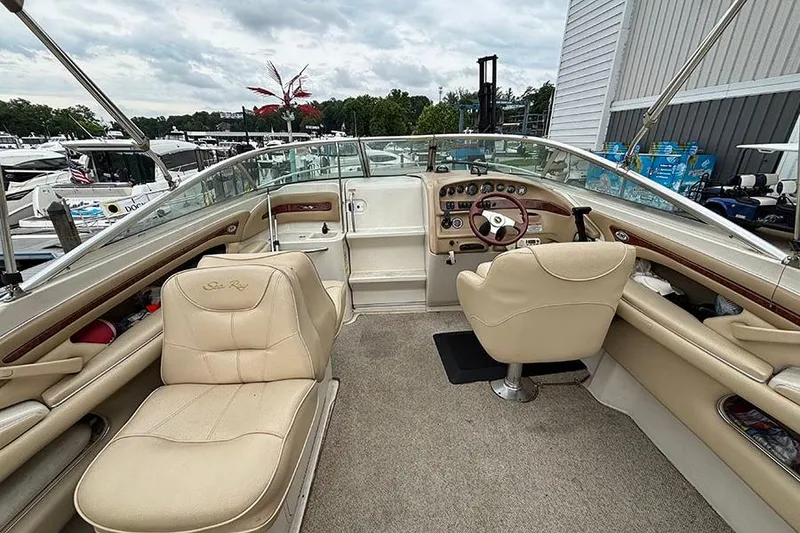 Slide: The Image of Interior of a 2000 Sea Ray 230 Overnighter boat with beige seating and dashboard. - 11