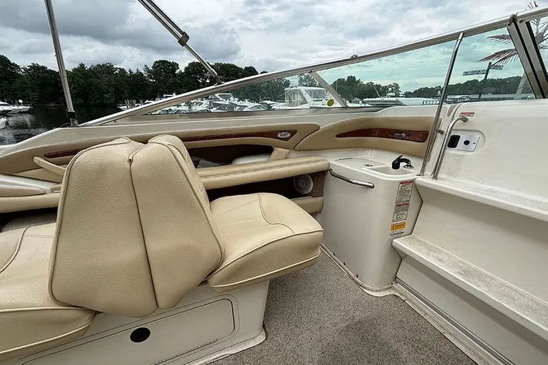 Slide: The Image of Interior of a 2000 Sea Ray 230 Overnighter boat with beige seating and wood accents. - 16