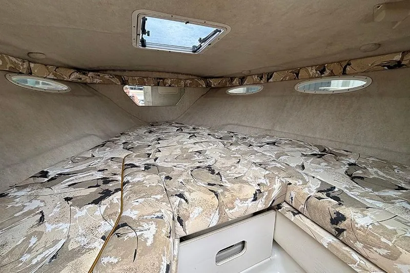 Slide: The Image of Interior cabin of a 2000 Sea Ray 230 Overnighter with patterned upholstery and porthole windows. - 20
