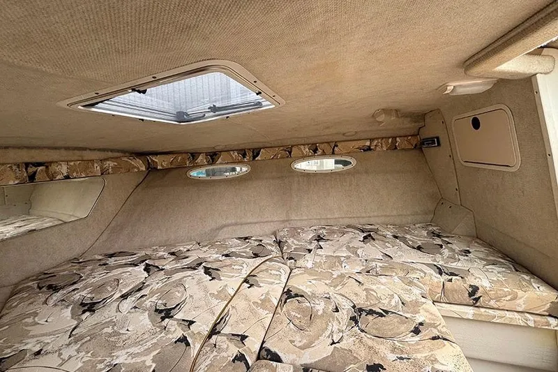 Slide: The Image of Interior cabin of 2000 Sea Ray 230 Overnighter with patterned cushions and small windows. - 21