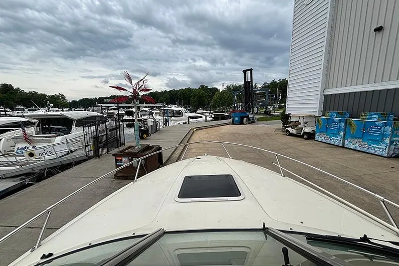 Slide: The Image of Bow view of a 2000 Sea Ray 230 Overnighter docked at a marina. - 24