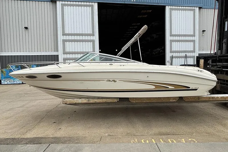 Slide: The Image of 2000 Sea Ray 230 Overnighter boat on trailer outside a large warehouse. - 4