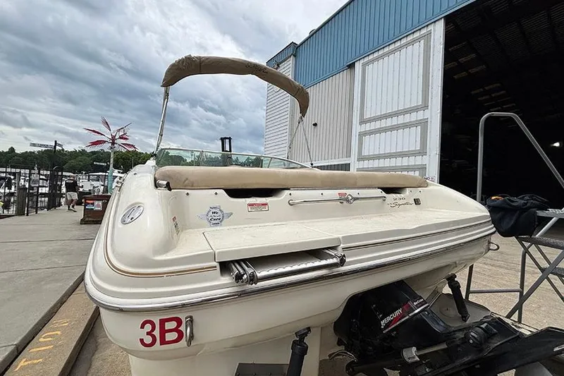 Slide: The Image of 2000 Sea Ray 230 Overnighter boat docked near a marina, rear view. - 7