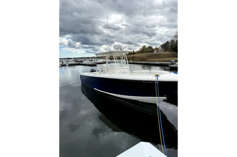 The Image of 2016 Sailfish 270 CC boat docked in a marina under cloudy skies. - 0