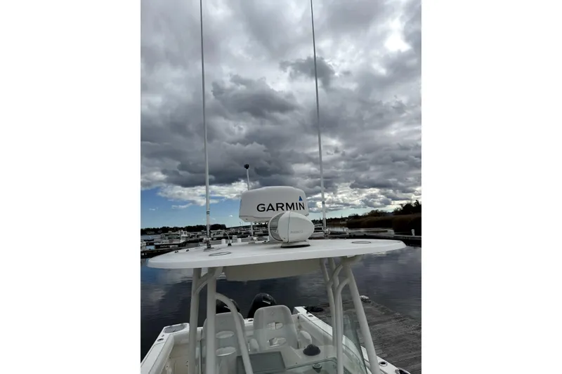 Slide: The Image of 2016 Sailfish 270 CC boat with Garmin radar, docked under cloudy skies. - 3