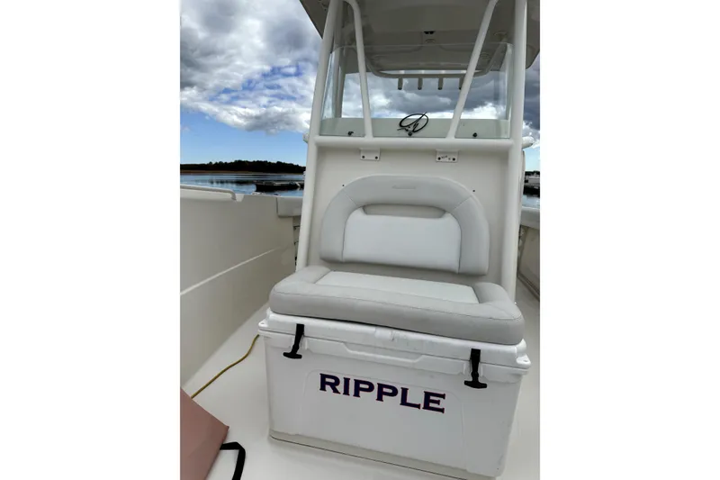 Slide: The Image of 2016 Sailfish 270 CC boat interior with cushioned seating and "RIPPLE" cooler. - 6