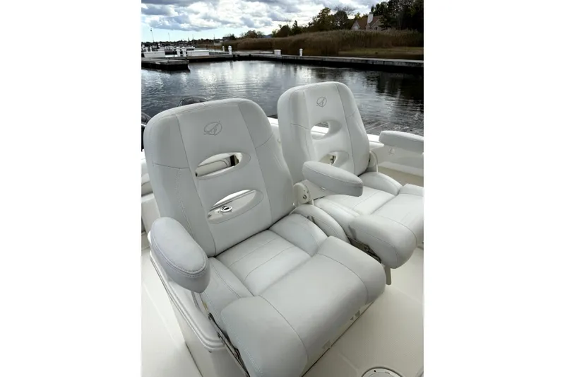 Slide: The Image of Luxury seating on 2016 Sailfish 270 CC boat, docked by a serene waterfront. - 9