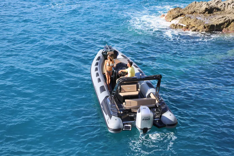 Slide: The Image of 2023 Ranieri CAYMAN 26 SPORT TOURING boat cruising near rocky shore. - 11