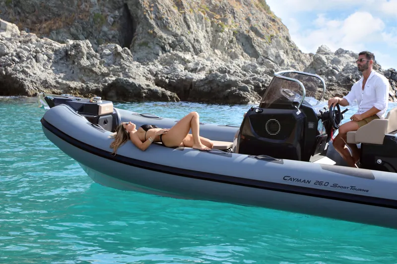 Slide: The Image of 2023 Ranieri CAYMAN 26 SPORT TOURING boat cruising in clear blue waters. - 13