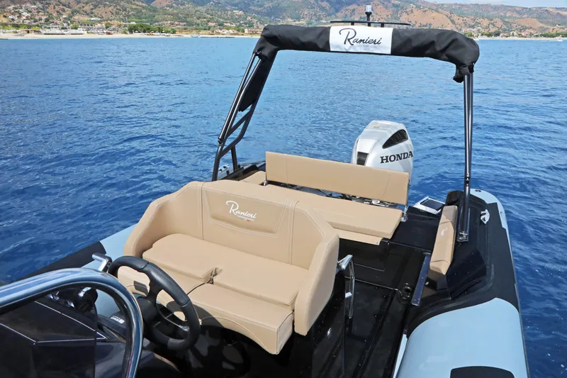 Slide: The Image of 2023 Ranieri CAYMAN 26 SPORT TOURING boat on blue water with Honda outboard motor. - 18