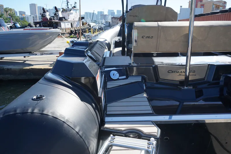 Slide: The Image of 2023 Ranieri CAYMAN 26 SPORT TOURING boat docked at marina with city skyline in background. - 23