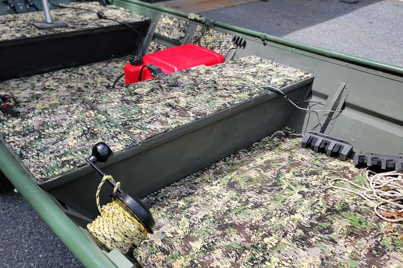 Slide: The Image of 1994 Alumacraft 1436 Jon boat interior with camouflage flooring and red fuel tank. - 3