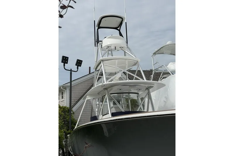 Slide: The Image of 2022 Valhalla Boatworks V-41 with tower, docked near a house, under cloudy sky. - 12