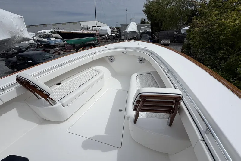 Slide: The Image of 2022 Valhalla Boatworks V-41 with white seating and sleek design in a marina setting. - 23