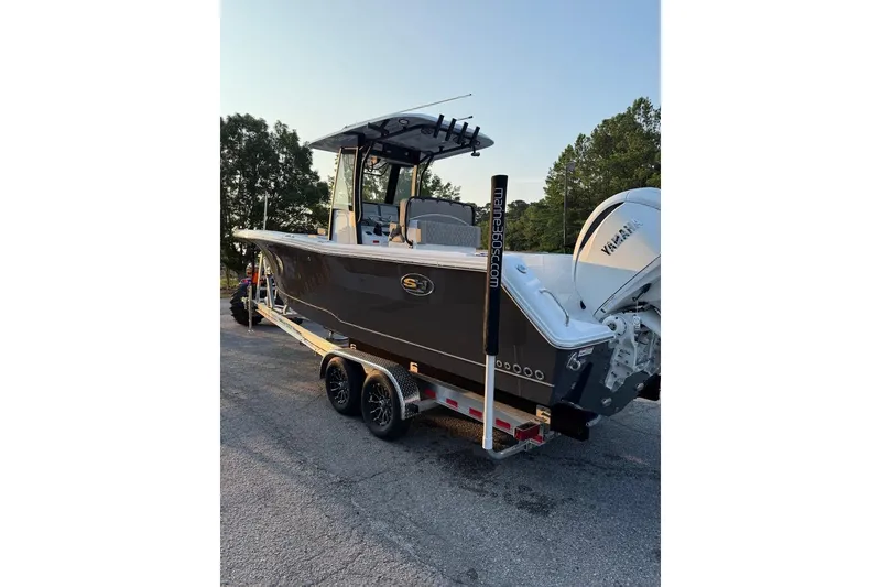 Slide: The Image of 2026 Sea Hunt Gamefish 27 Coffin Box boat on trailer, parked outdoors. - 3