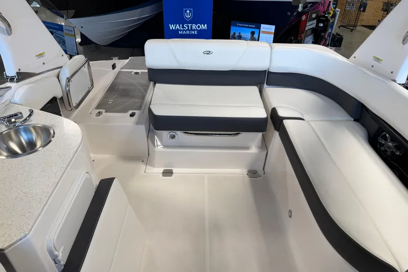 Slide: The Image of Interior of a 2016 Regal 2550 Cuddy boat with white seating and a small sink. - 13