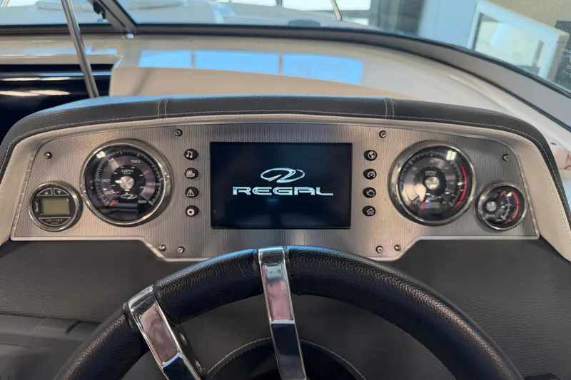 Slide: The Image of Dashboard of a 2016 Regal 2550 Cuddy boat with gauges and logo display. - 20