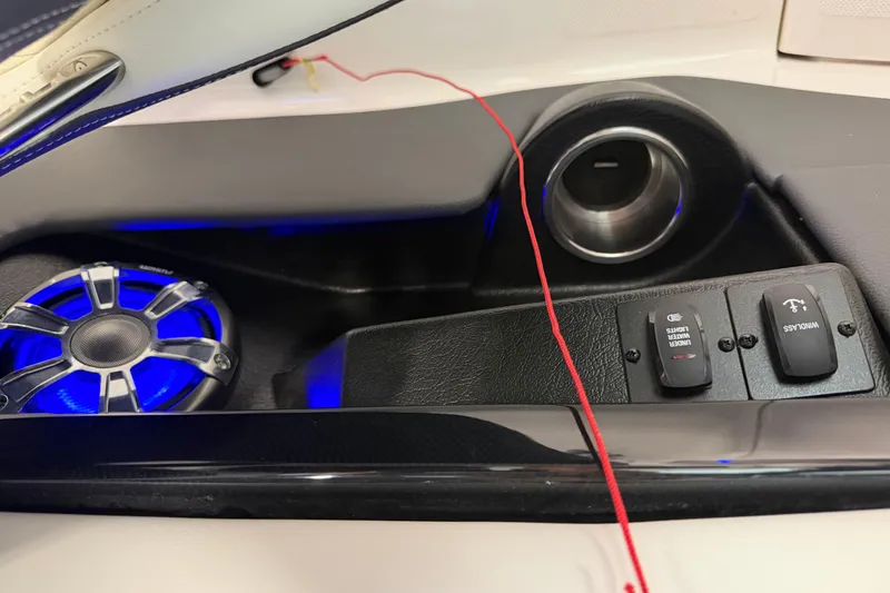 Slide: The Image of Control panel of a 2016 Regal 2550 Cuddy boat with illuminated speaker and switches. - 23