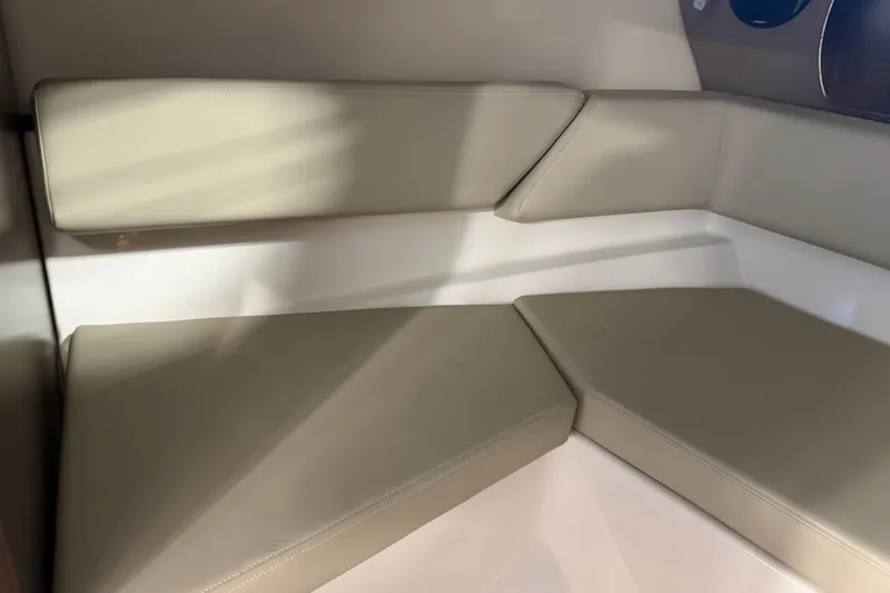 Slide: The Image of Interior seating of 2016 Regal 2550 Cuddy boat with beige cushions. - 24