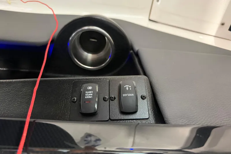 Slide: The Image of Dashboard switches on a 2016 Regal 2550 Cuddy boat, featuring under water lights and windlass controls. - 26