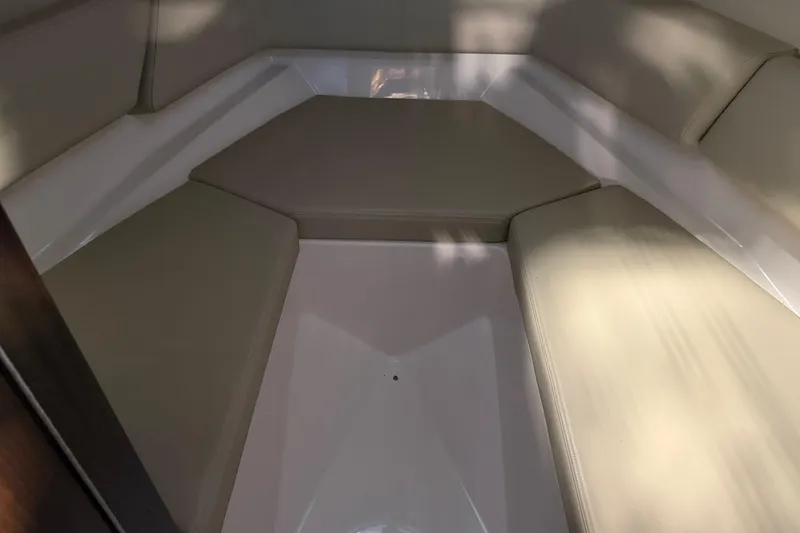 Slide: The Image of 2016 Regal 2550 Cuddy cabin interior with beige seating and white accents. - 28