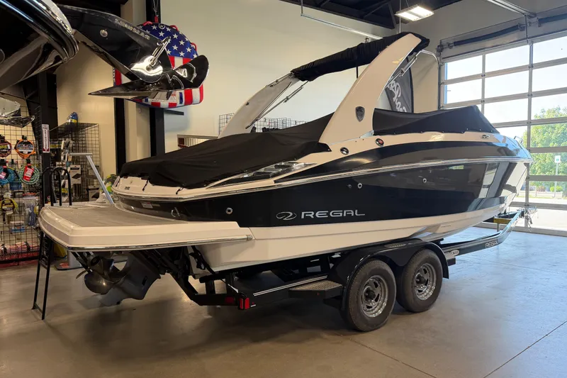Slide: The Image of 2016 Regal 2550 Cuddy boat on trailer in showroom, black and white design. - 6