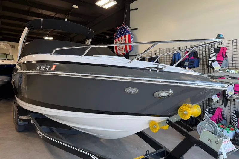 Slide: The Image of 2016 Regal 2550 Cuddy boat displayed indoors with accessories in the background. - 7