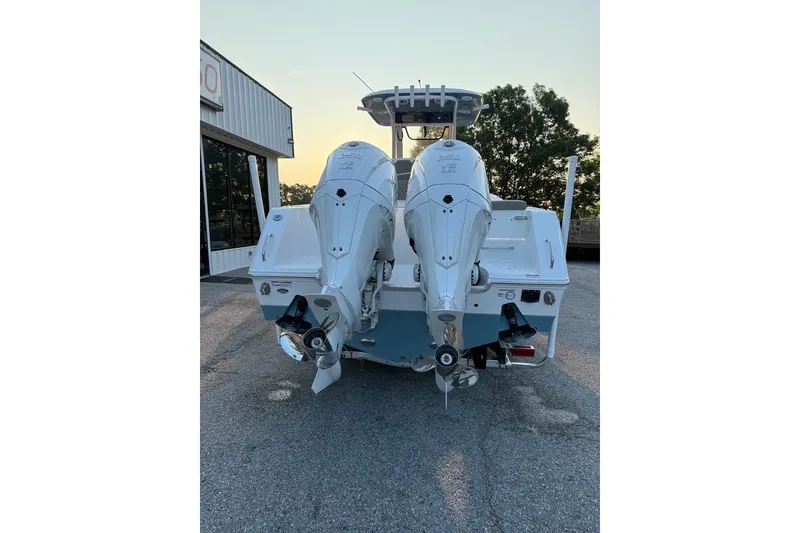 Slide: The Image of 2026 Sea Hunt Gamefish 27 boat with dual outboard engines, parked outdoors. - 2