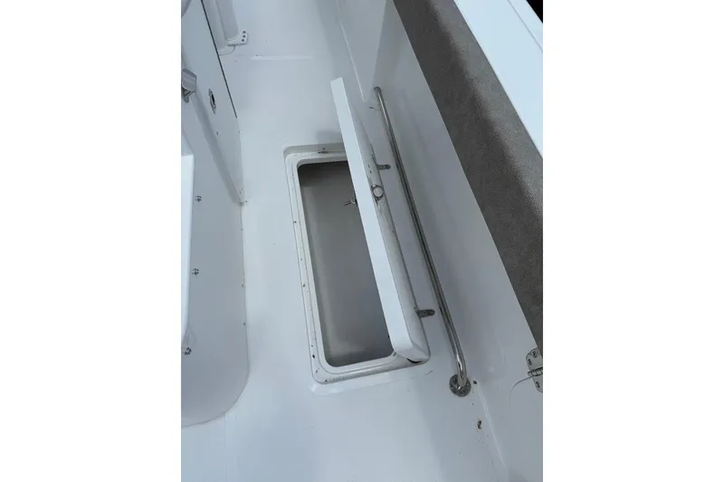 Slide: The Image of 2026 Sea Hunt Gamefish 27 Forward Seating storage compartment, open view, white interior. - 22